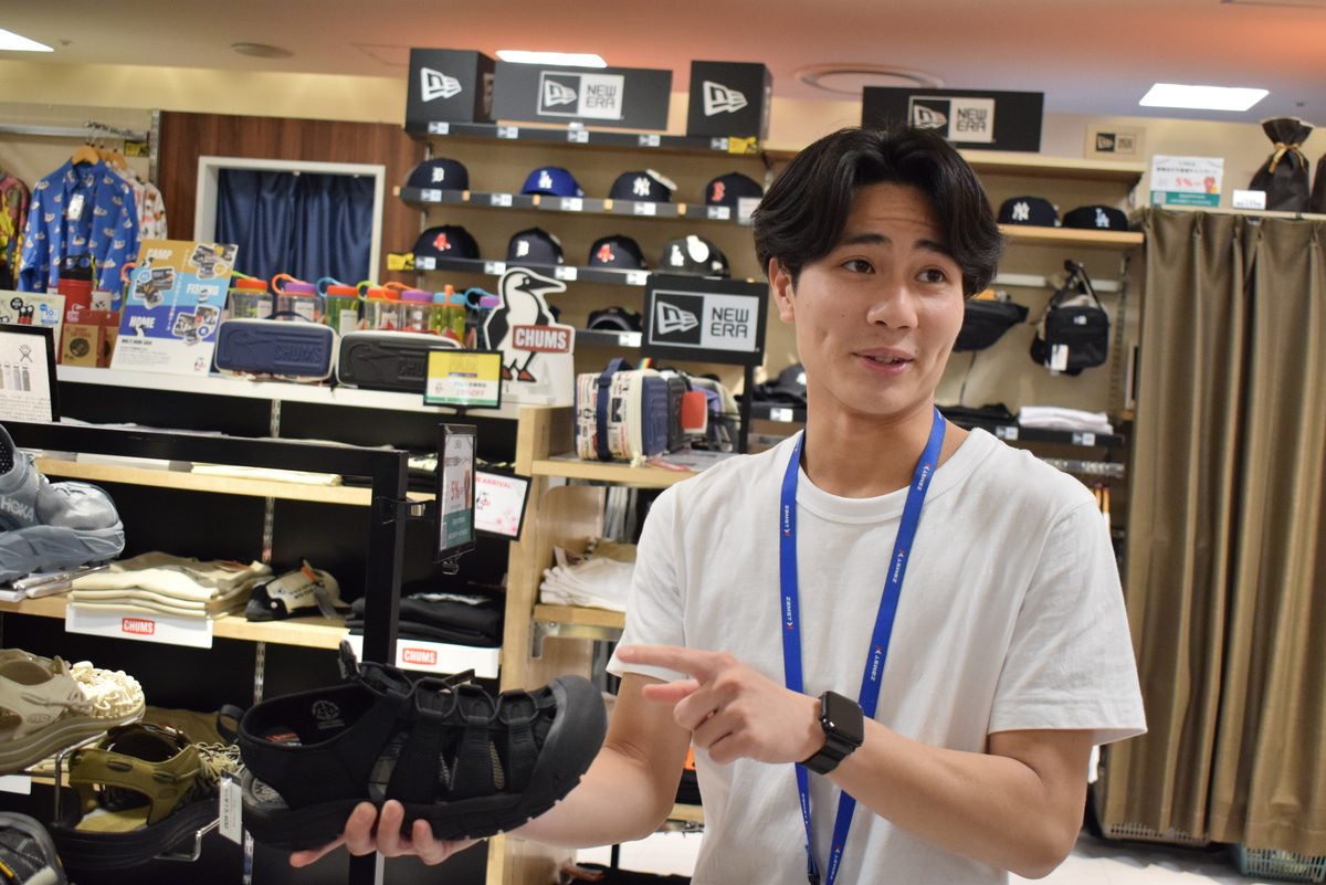 商品を手にお客様に接客するスタッフ